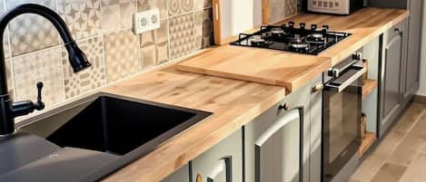 Una cocina con isla central, estufa integrada y microondas.