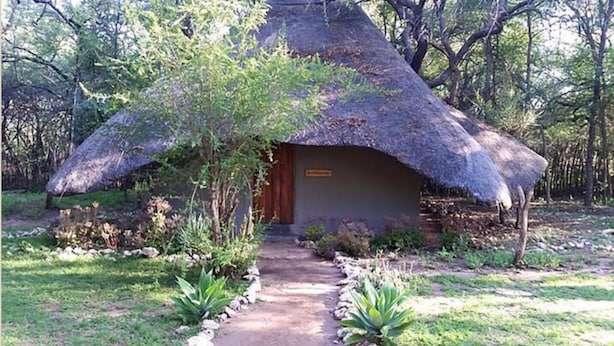 A thatched-roof hut with a wooden door and a sign above it. - Chinaka Game Lodge (Vivo)