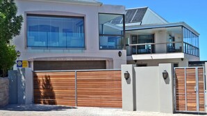 A modern two-story house with large windows, a garage, and a balcony. - Kite Mansion Penthouse (Langebaan)