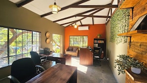 Una habitación con escritorio, silla, estantería y sofá.