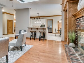 A modern kitchen with white cabinets, a central island, and bar stools. - WARWICK POOL AND SPA HEATED POOL OPEN ALL YEAR LONG (Oklahoma City)