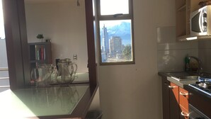 A compact kitchen with a window, a microwave, and a gas stove.