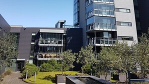 Un immeuble moderne à plusieurs étages, doté de nombreux balcons et de grandes fenêtres.