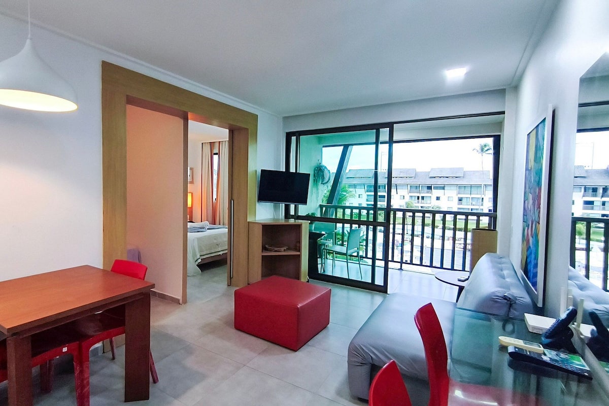 Uma sala de estar moderna com área de jantar, televisão e varanda com vista.