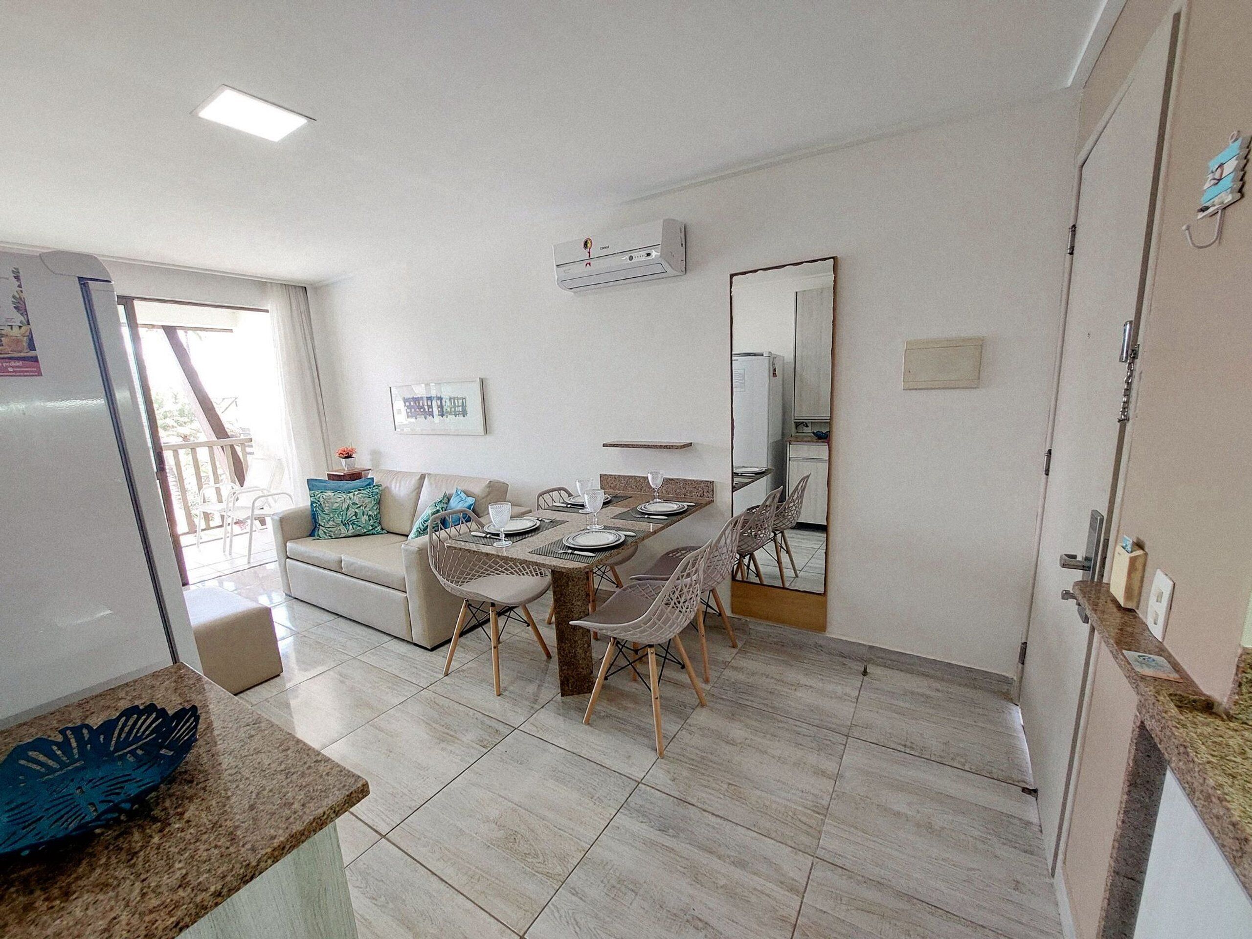 A compact living space with a dining area, kitchenette, and a balcony.