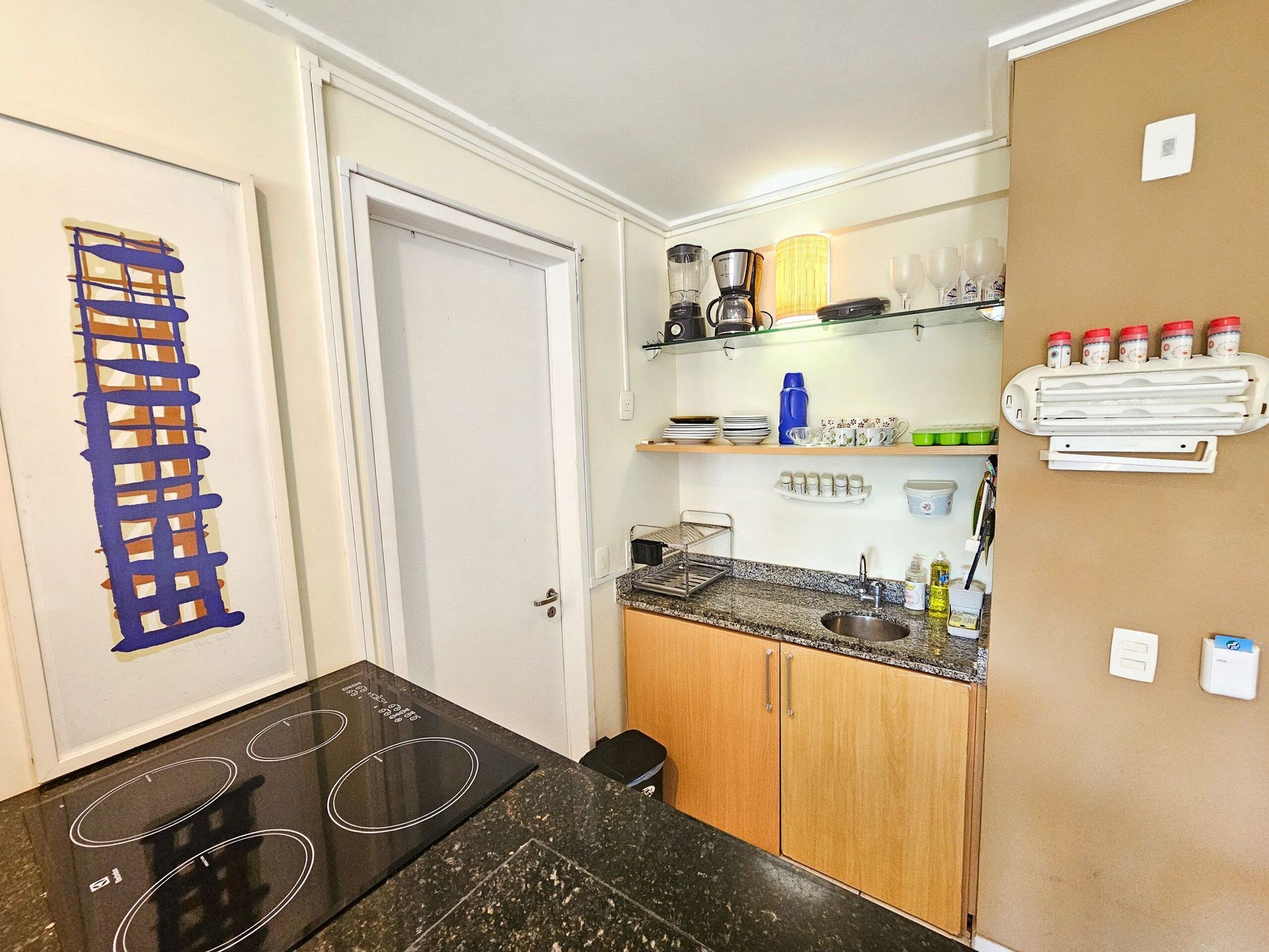 A compact kitchen with a built-in stovetop, a coffee maker, and a microwave.