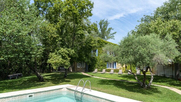 A swimming pool with a metal ladder, surrounded by lush green trees and a well-maintained lawn. - rental in the heart of Provence with private pool secured (Grans)