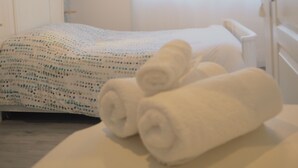 A neatly made bed with a patterned bedspread and two rolled towels. - rental in the heart of Provence with private pool secured (Grans)