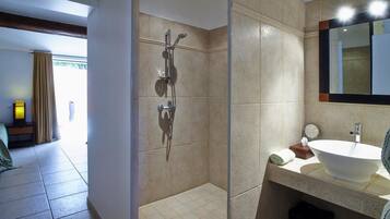 Une salle de bain moderne avec une douche à l’italienne, un grand lavabo et un miroir.