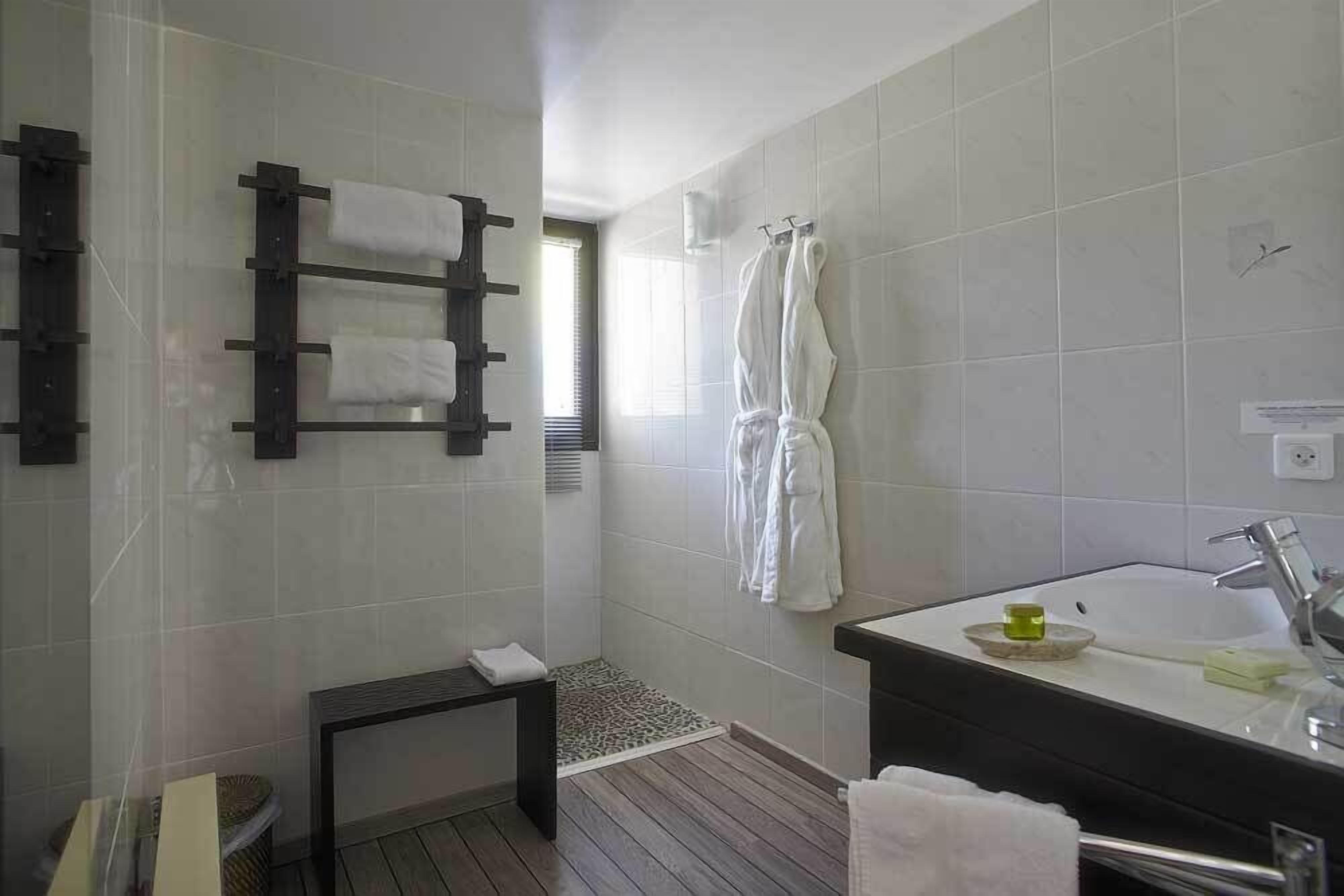 Une salle de bain moderne équipée d’une douche, d’un lavabo et d’un porte-serviettes.