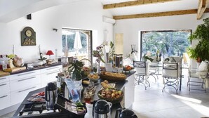 Una cocina amplia con comedor, ventanas grandes y vistas a zonas verdes.
