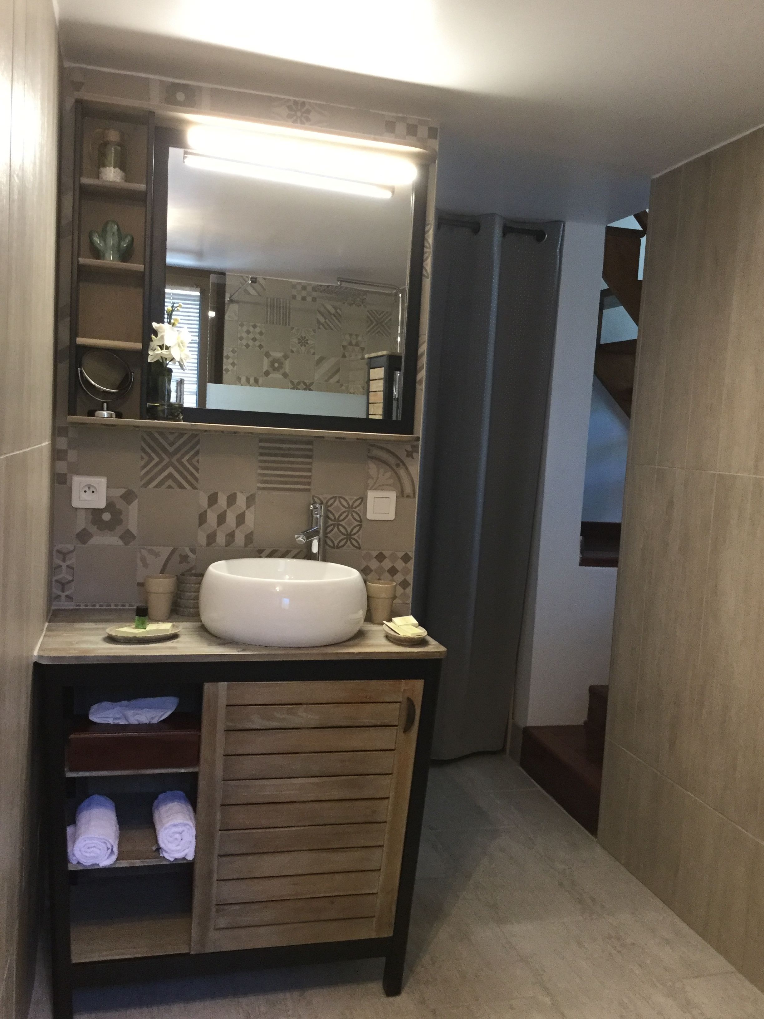 Een badkamer met een grote spiegel, een wastafel en een handdoekrek.