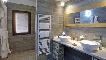 Een moderne badkamer met twee wasbakken, een grote spiegel en een handdoekhouder.