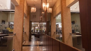 A modern hotel lobby with a central staircase, mirrored walls, and hanging chandeliers. - Ibituruna Center Hotel (Governador Valadares)