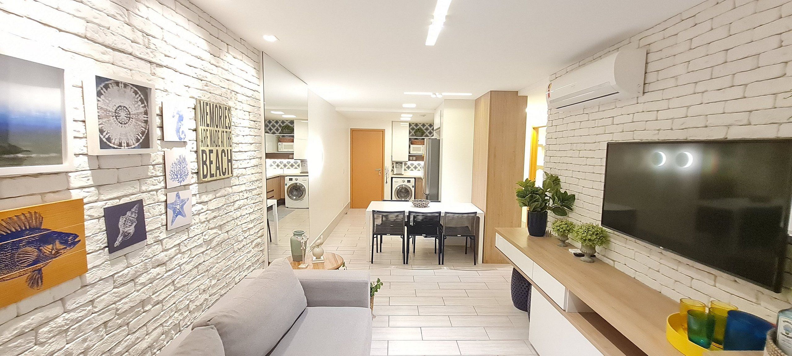 Una sala de estar moderna con sofá, mesa de comedor y televisor.