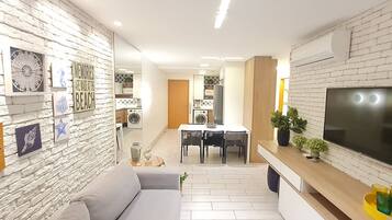 Un salon moderne avec un canapé, une table à manger et un téléviseur.