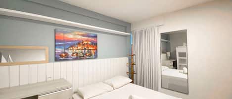 Une chambre d’hôtel avec un lit, une commode, un tableau, un miroir et une fenêtre avec des rideaux.