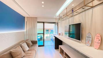 Apartamento família, vista para a piscina | Área de estar | TV de tela plana