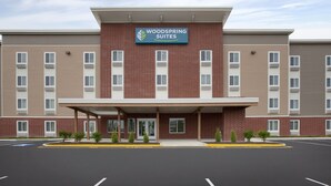 A hotel with a brick facade, a covered entrance, and a sign reading "Woodspring Suites". - WoodSpring Suites Quantico (Stafford)