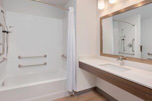 Un baño con bañera, ducha, lavabo y espejo.