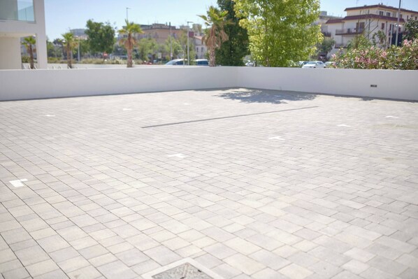 A paved outdoor area with a white wall and a corner. - West Village Appartamento - NUOVO con piscina (Jesolo)