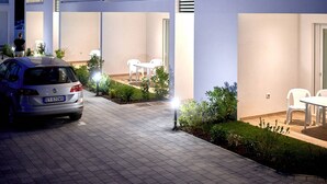 Ein mehrstöckiges Gebäude im modernen Stil, mit Balkonen und Glasgeländern sowie Außenbereichen zum Sitzen.