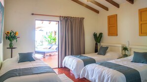 Une chambre d’hôtel avec deux lits, un ventilateur de plafond et une vue sur l’extérieur.