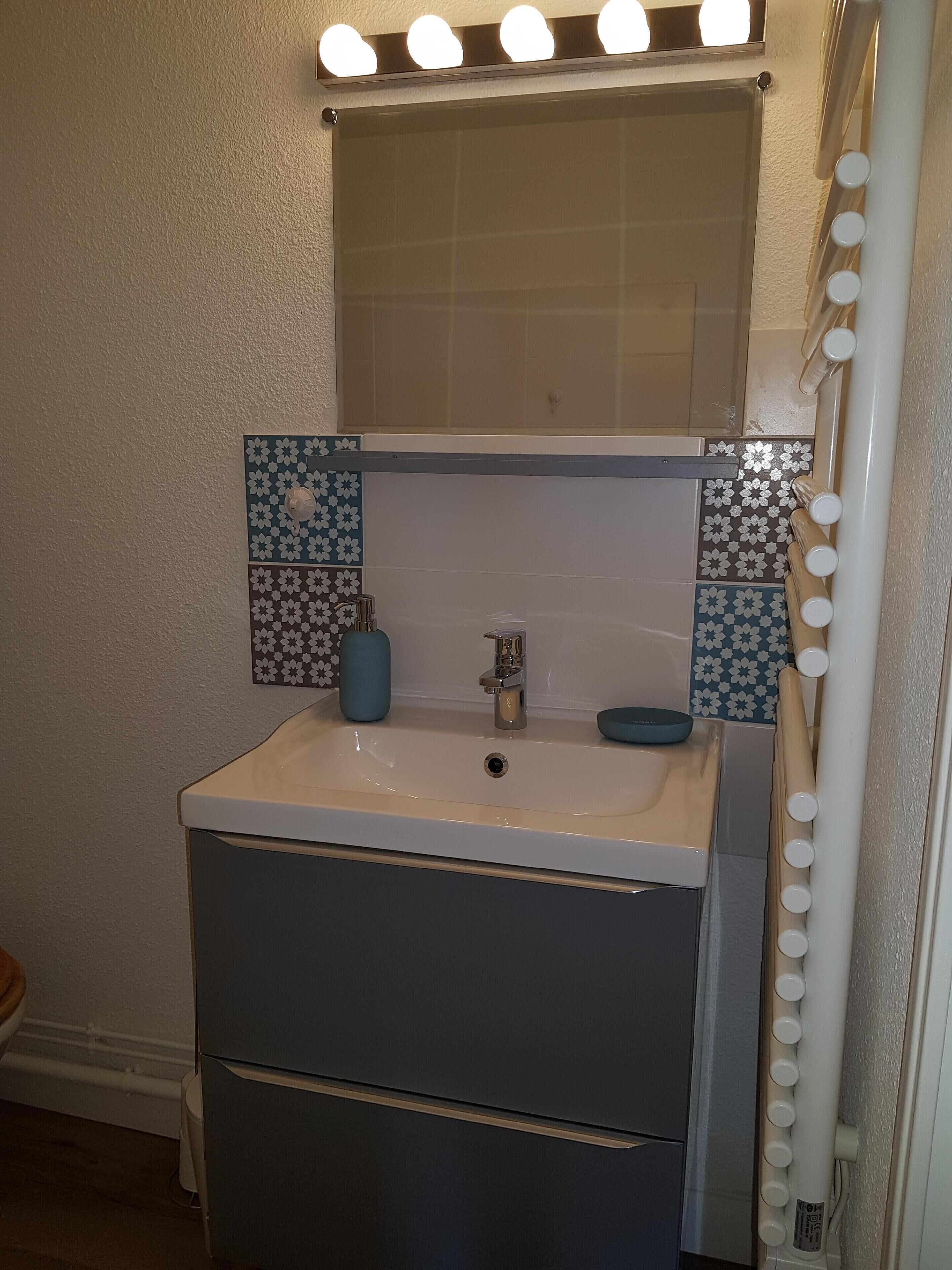 A bathroom with a sink, mirror, and vanity.