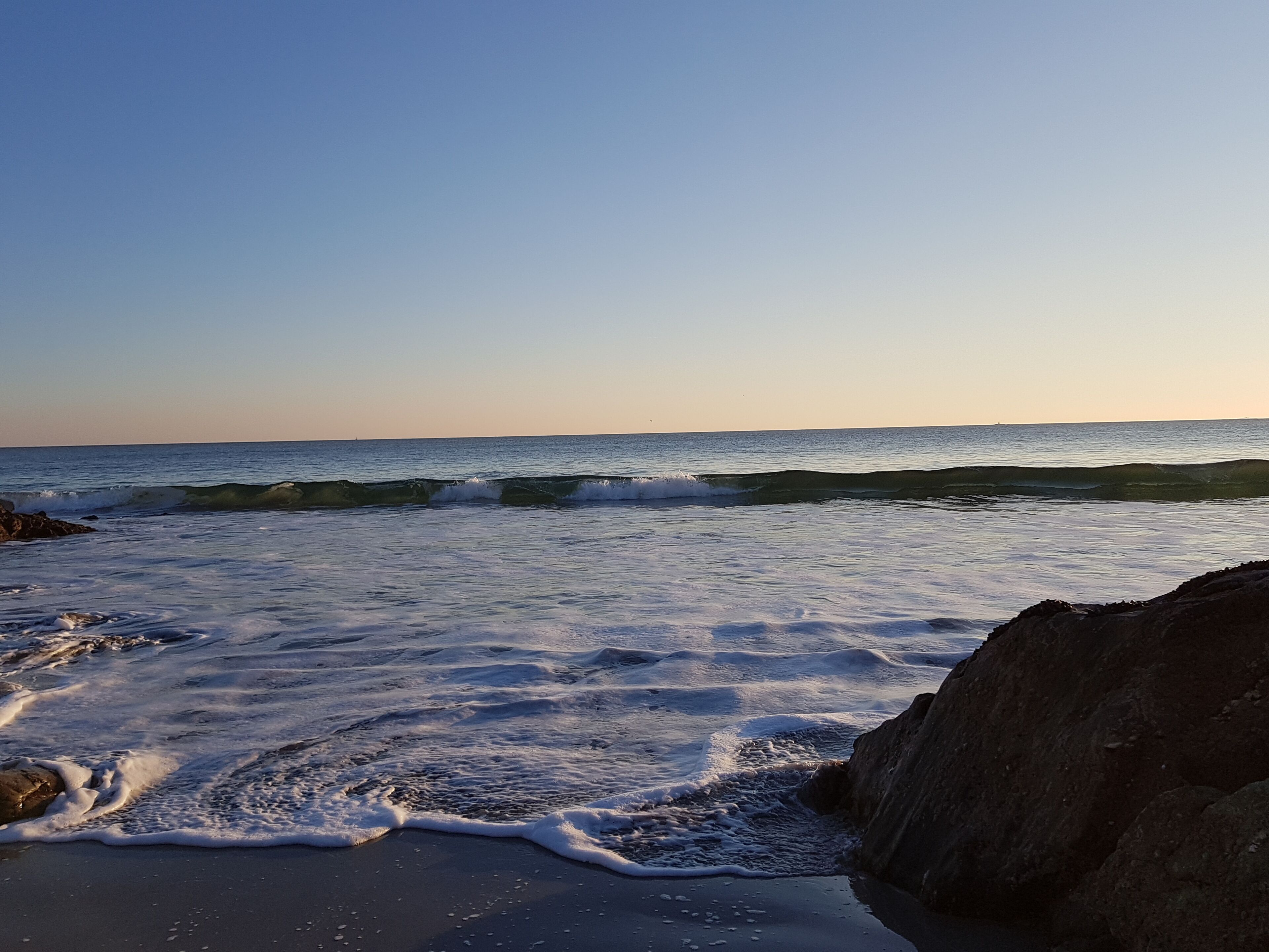 Una playa con olas y rocas.