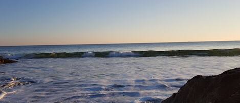 Una playa con olas y rocas.