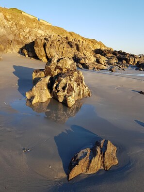 Una playa rocosa con grandes rocas y un cielo despejado.