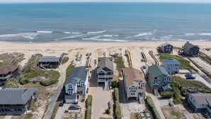 A coastal residential area with houses, a beach, and a view of the ocean. - 5849- Mari-Time, Oceanfront 8BR Luxury: Theater, Pool & Elevator (South Nags Head)