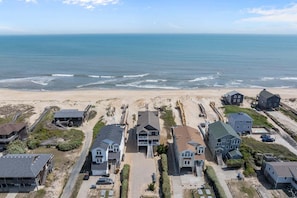A coastal residential area with houses, a beach, and a view of the ocean.