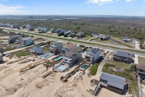 Zona residencial à beira-mar, com várias casas, uma praia e uma estrada.