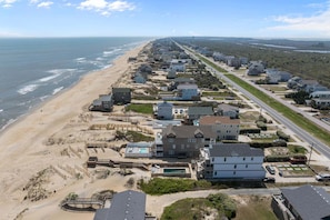 Une zone résidentielle côtière comprenant des maisons, une plage et une route.