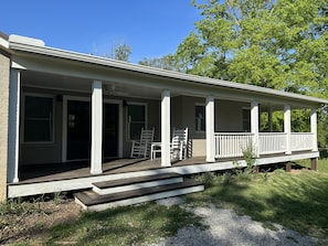 Ein eingeschossiges Haus mit einer Veranda und einer kleinen Treppe zum Eingang.