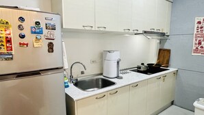 A compact kitchen with a refrigerator, sink, and stove.