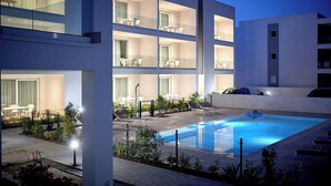 Un hôtel moderne doté d’une piscine sur le toit, de nombreux balcons et d’espaces de détente en plein air.