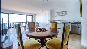 Un comedor con una mesa redonda de madera, sillas tapizadas de color amarillo y un candelabro.