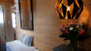 A wooden interior with a white sofa, striped pillow, and a vase of flowers on a table. - for two Holidays in an organic wooden house - in harmony with nature (Leutasch)