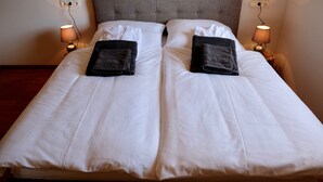 A neatly made double bed with white linens, two pillows, and two folded towels on each side. - for two Holidays in an organic wooden house - in harmony with nature (Leutasch)