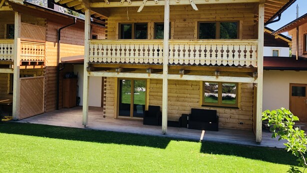 A wooden chalet with a balcony, large windows, and a view of mountains. - for two Holidays in an organic wooden house - in harmony with nature (Leutasch)