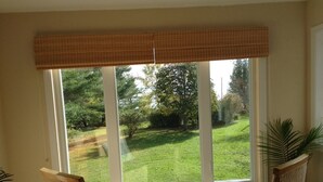 A room with a large window, wicker chairs, and a view of a green lawn. - Bay of Fundy ,Cobequid Bay, Steps to  the beach in  the Cliffs of Fundy Geopark (Economy)