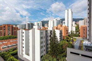 A high-rise building with multiple floors, surrounded by other buildings and greenery. - Alcazar de Oviedo by Nomad Guru (Medellín)
