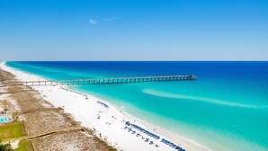 A beach with a long pier extending into the ocean, white sand, and clear turquoise water. - Awesome East Side Condo- Sea Forever (Navarre)