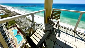 A balcony with a view of a beach, a pool, and a pier. - Awesome East Side Condo- Sea Forever (Navarre)