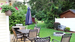 A patio with a grill, table, chairs, and a hanging planter. - Cooperstown Baseball Rentals - Lakeview Pines (Maryland)
