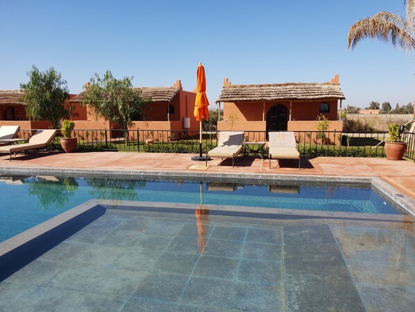 Piscine extérieure, parasols de plage, chaises longues