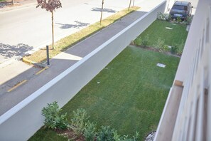 A view of a well-maintained lawn with a sidewalk and a parked car.