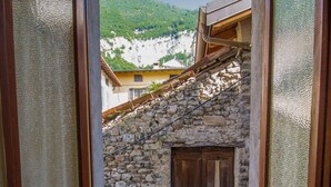 A room with a view of a stone building and a wooden door. There are towels on the floor.